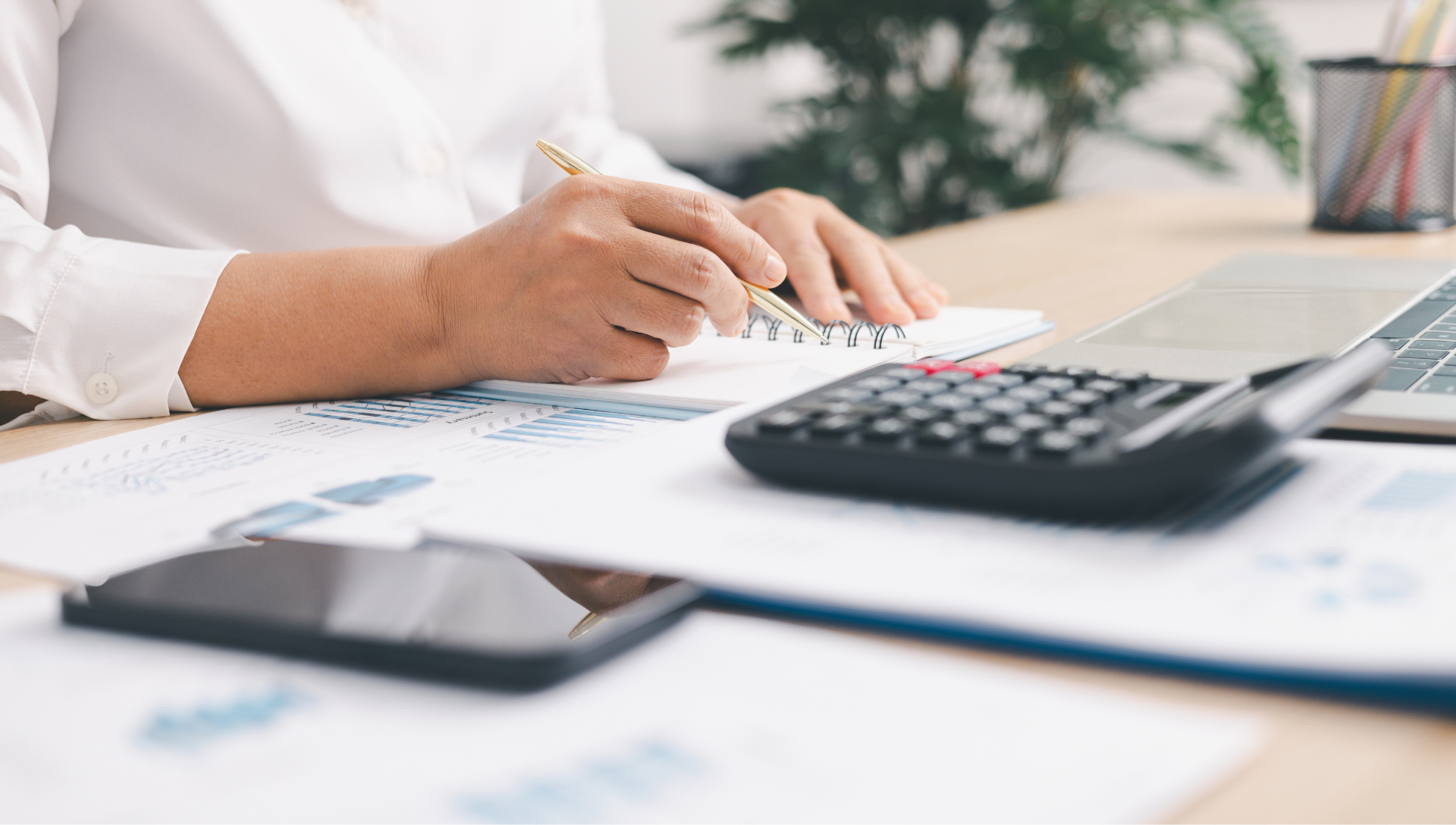 Professional reviewing financial statements and business performance reports with calculator and laptop